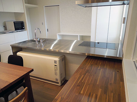 特殊な暖房機のスペースを確保した対面キッチン