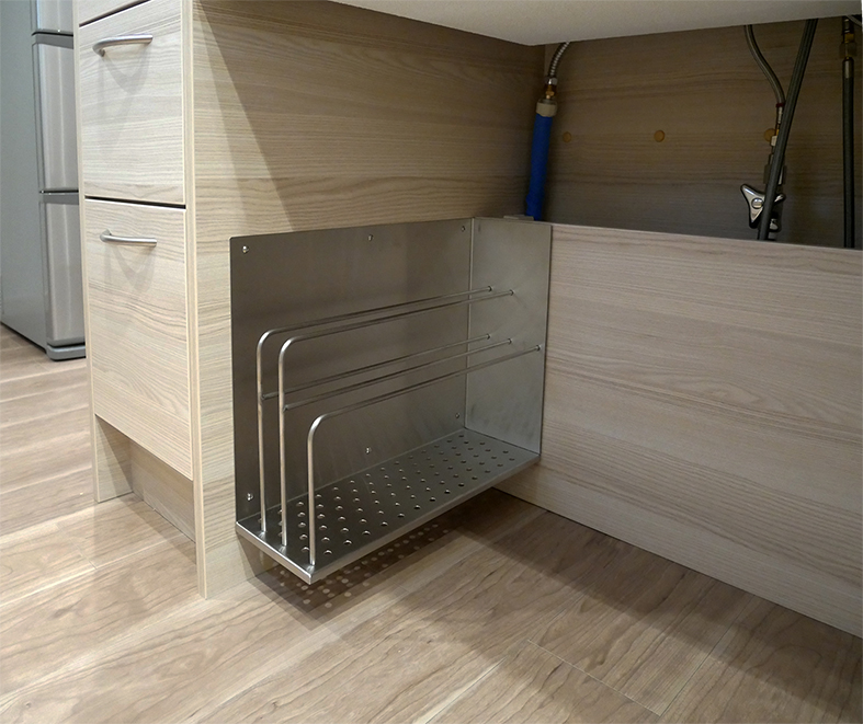 オーダーキッチンのシンク下にはまな板や調理プレートの専用棚を設置