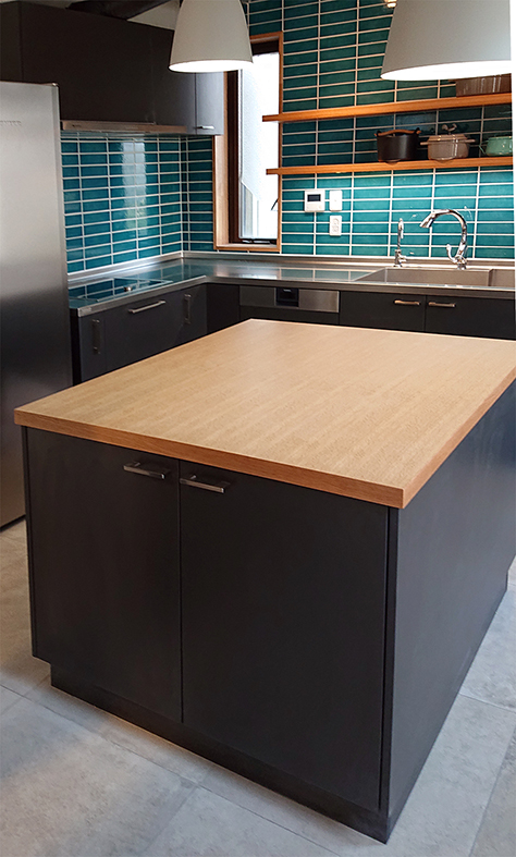 Ｌ型のステンレスカウンターとオークの柾目突板のアイランドキッチン